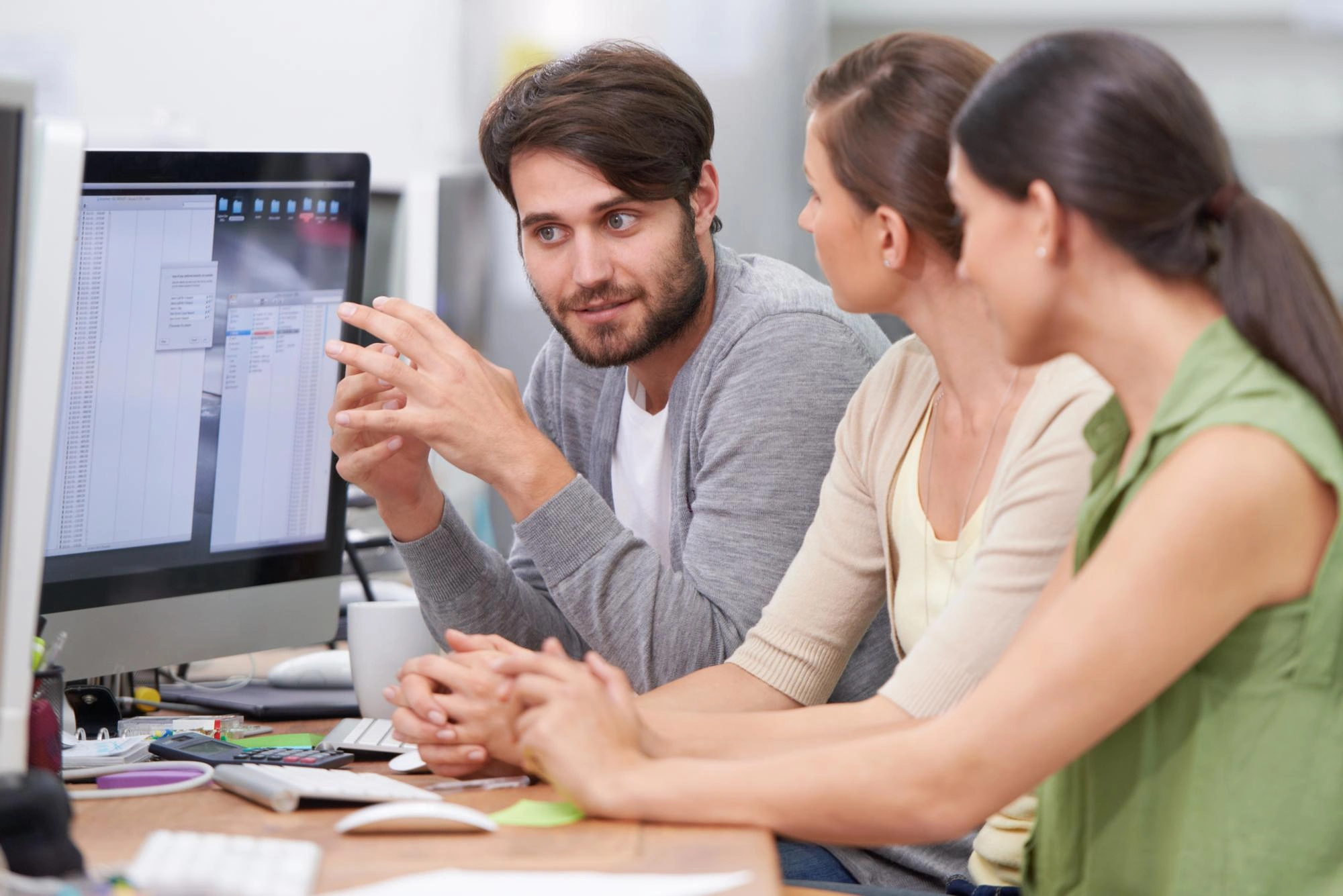 IT developer vysvětlující kolegyním z marketingu funkci webové aplikace s AI funkcemi