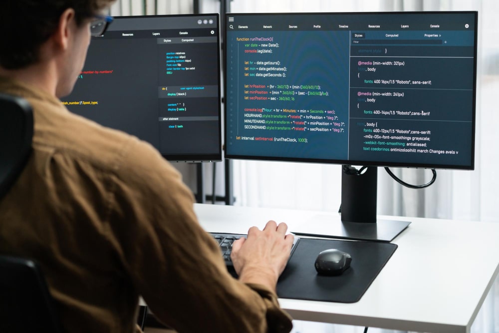 Programátor pracující na webové aplikaci u počítače
